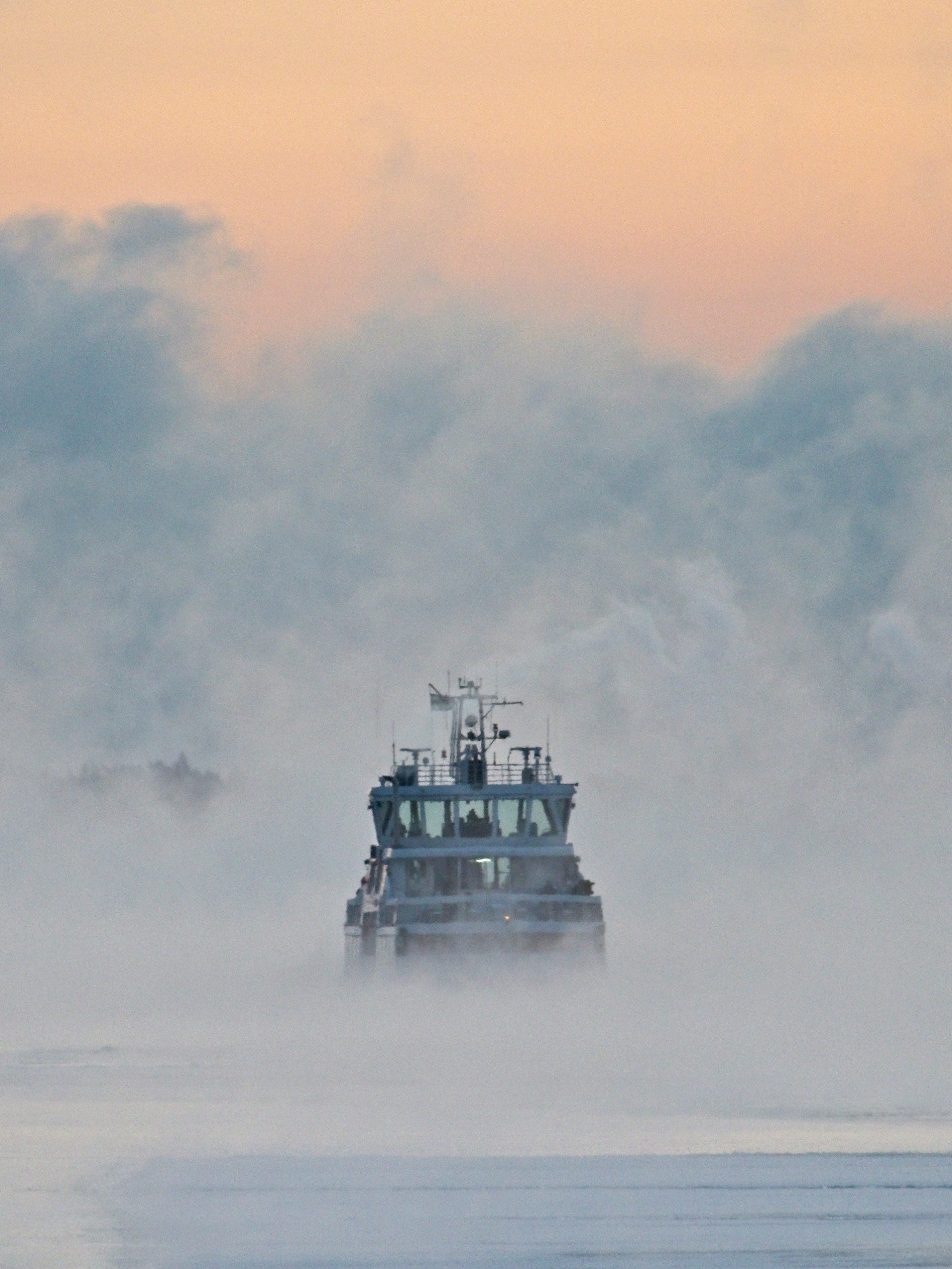 white ship on sea under white clouds